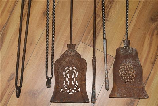 A set of three George III steel and brass fire irons and a set of three steel fire irons